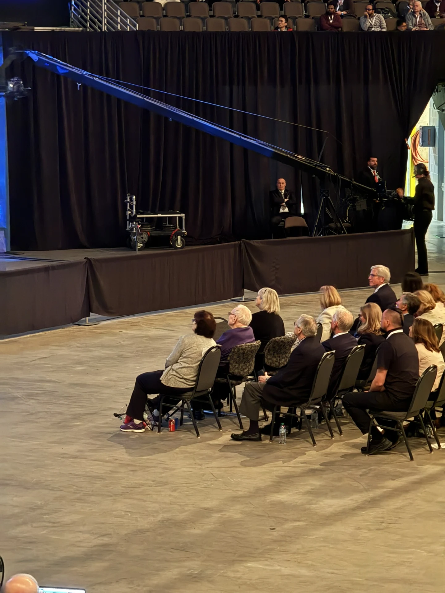 Audience members seated near the arena floor and production equipment at the Berkshire Hathaway annual meeting.